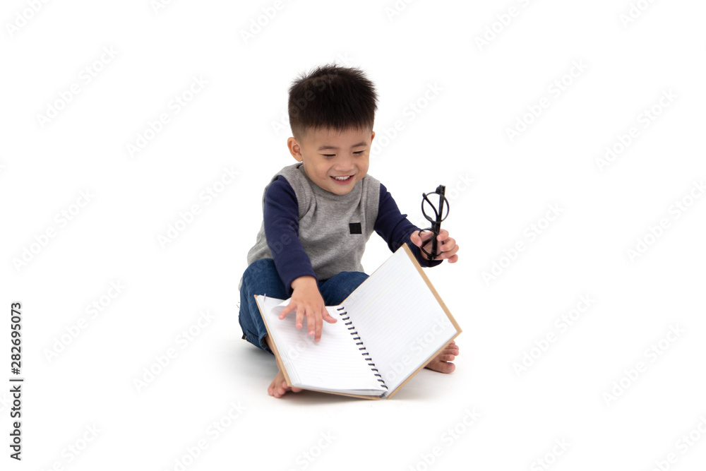 Portrait of a cute Asian little boy sitting on floor and reading a book isolated over white background, Back to school concept, 1 year 10 month old Portrait of a cute Asian little boy sitting on floor and reading a book isolated over white background, Back to school concept, 1 year 10 month old