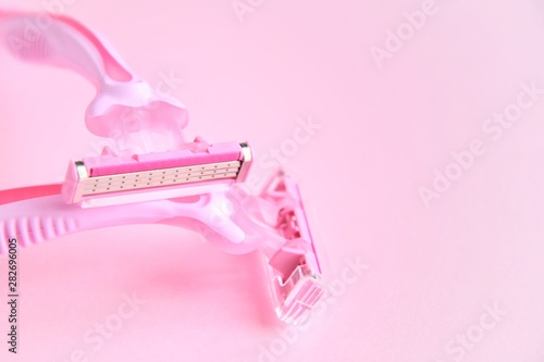 New pink disposable razors for safe shaving of female skin with selective focus on pink background with copy space. Razor for smooth shaving. Sharp razors for personal hygienic routine 