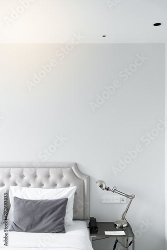 Cozy bedroom corner in minimal modern style with empty cool gray painted wall in the background / in terior concept / background for advertising.