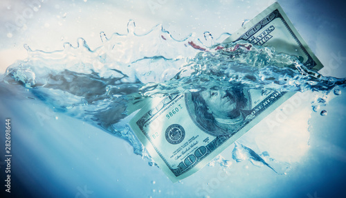 Global financiall crisis concept. Dramatic image of US Dollar sinking in water photo