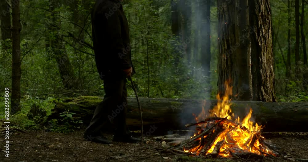 an elderly man photographer resting in the woods in the evening over a fire an elderly man photographer resting in the woods in the evening over a fire