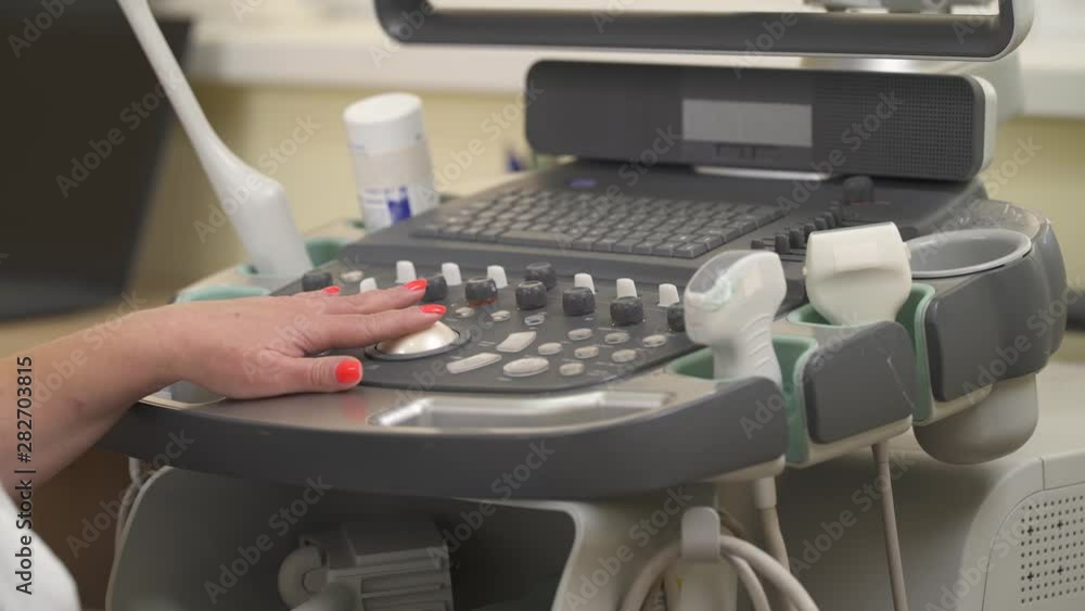 A front view of doctor working with high tech ultrasound machine. Ultrasound scanning. Medical concept. Isolated, on blurred background A front view of doctor working with high tech ultrasound machine. Ultrasound scanning. Medical concept. Isolated, on blurred background