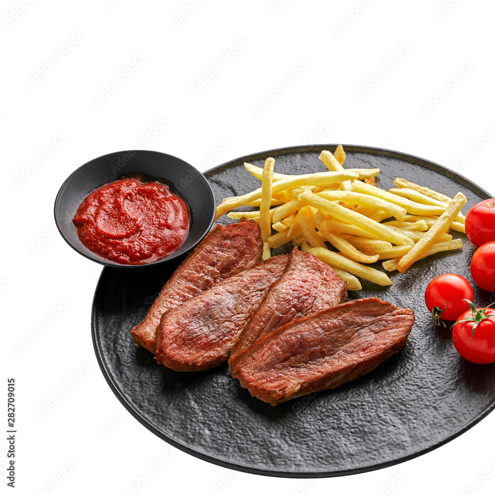 Steak with French fries, fresh cherry tomatoes and sauce isolated on white background. Wholesome classic American lunch on a black plate. Top view, directly above shot. Steak with French fries, fresh cherry tomatoes and sauce isolated on white background. Wholesome classic American lunch on a black plate. Top view, directly above shot.
