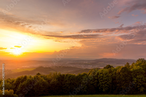 Meadow landscape countryside view with blue sky with many clouds sun light and forest close to city Valasske Mezirici captured during summer late time from hill.