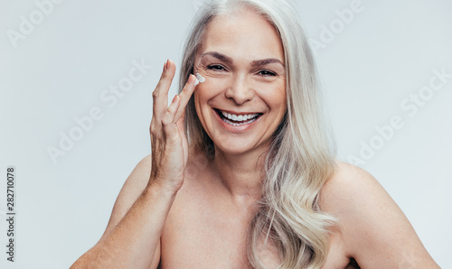 Woman applying anti aging cosmetic