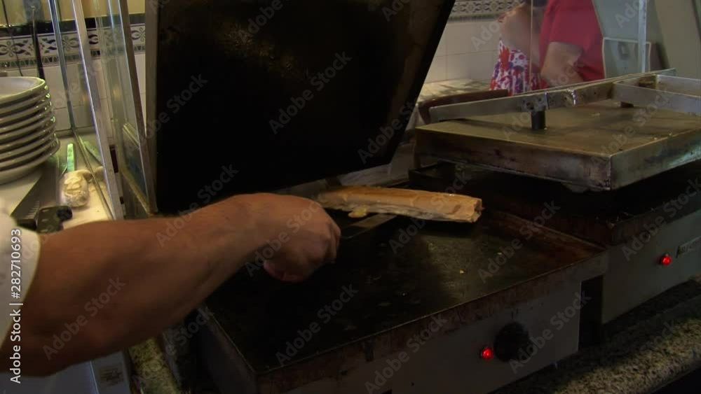 Medium closeup Cuban sandwich press and cut into sections in restaurant