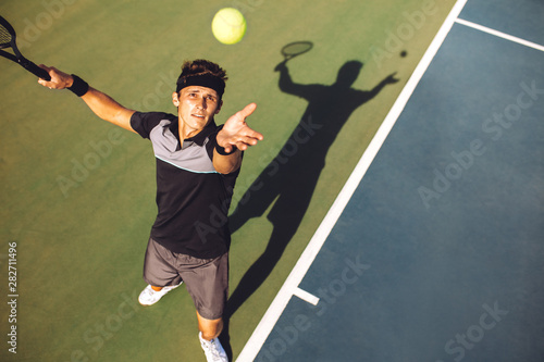Tennis player serving the ball in a match © Jacob Lund