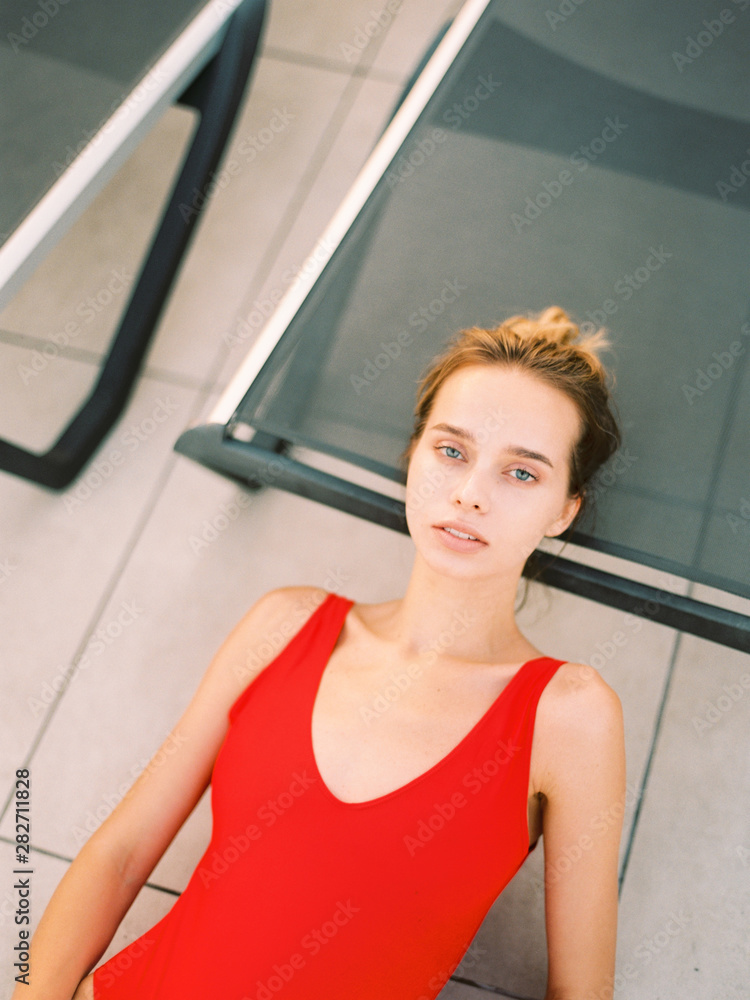 Beautiful young girl sitting near swimming pool Beautiful young girl sitting near swimming pool