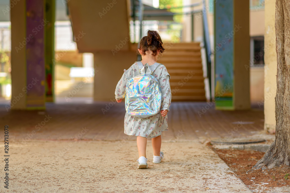 Fototapeta premium Pupil kid going to school with holographic schoolbag or satchel, child walking to school bus. Toddler first day at school or preschool.