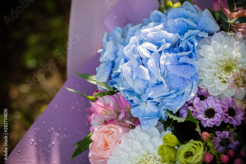 beautiful blossoming flower bouquet of fresh hydrangea, roses, eustoma, mattiola, flowers in blue, pink and white colors. rich bouquet with blue hydrangea, with water drops. Happy holidays gift. photo