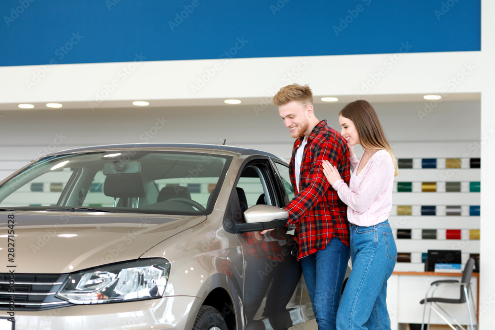 Couple choosing new car in salon Couple choosing new car in salon