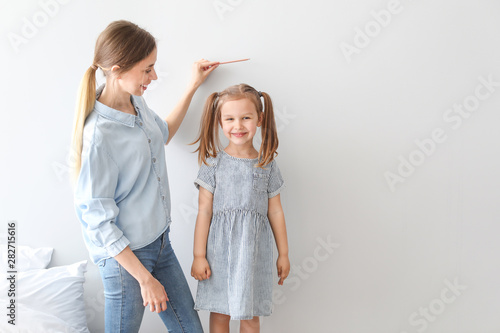 Young mother measuring heig...