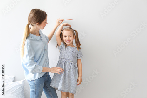 Young mother measuring heig...
