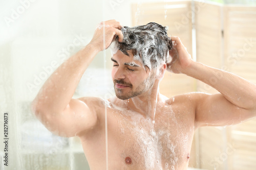 Handsome man washing hair at home
