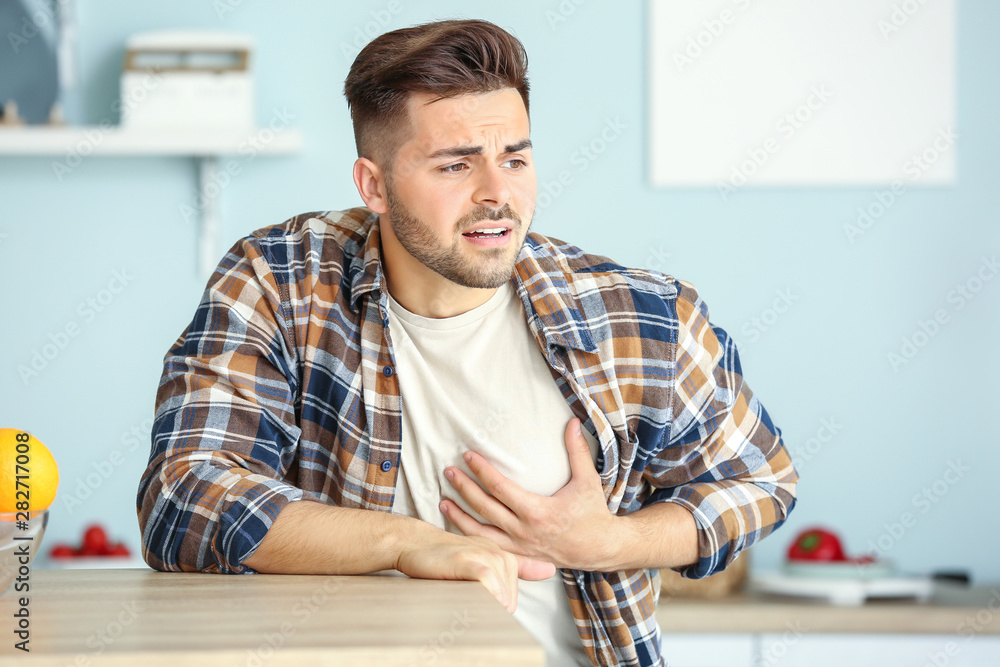 Young man suffering from heart attack at home