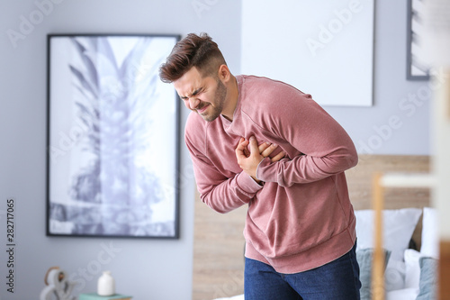 Young man suffering from heart attack at home