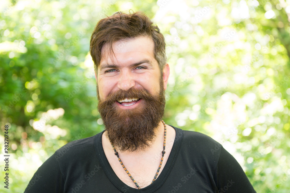 Hair cut for your face shape. Happy guy with shaped beard and styled hair. Hairy hipster with stylish beard and mustache hair on natural background. Bearded man smiling with unshaven face hair Hair cut for your face shape. Happy guy with shaped beard and styled hair. Hairy hipster with stylish beard and mustache hair on natural background. Bearded man smiling with unshaven face hair