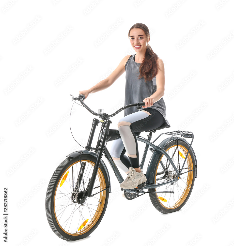 Sporty young woman riding bicycle against white background Sporty young woman riding bicycle against white background