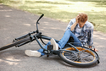 Young man fallen off his bicycle outdoors