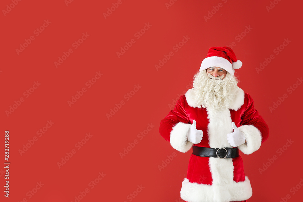 Portrait of Santa Claus showing thumb-up on color background