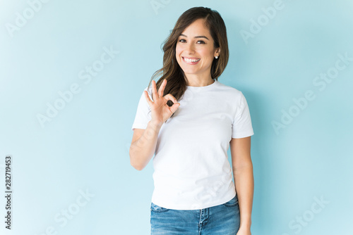 Brunette Appreciating With Hand Sign Over Blue Background photo