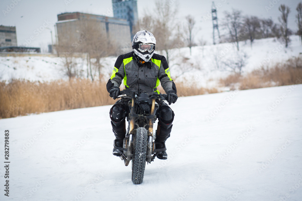 A guy rides a motorcycle on a frozen lake