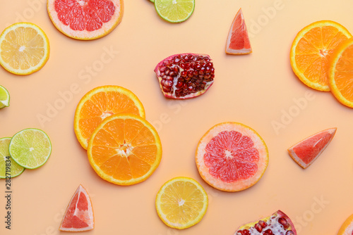 Different sliced citrus fruits on color background