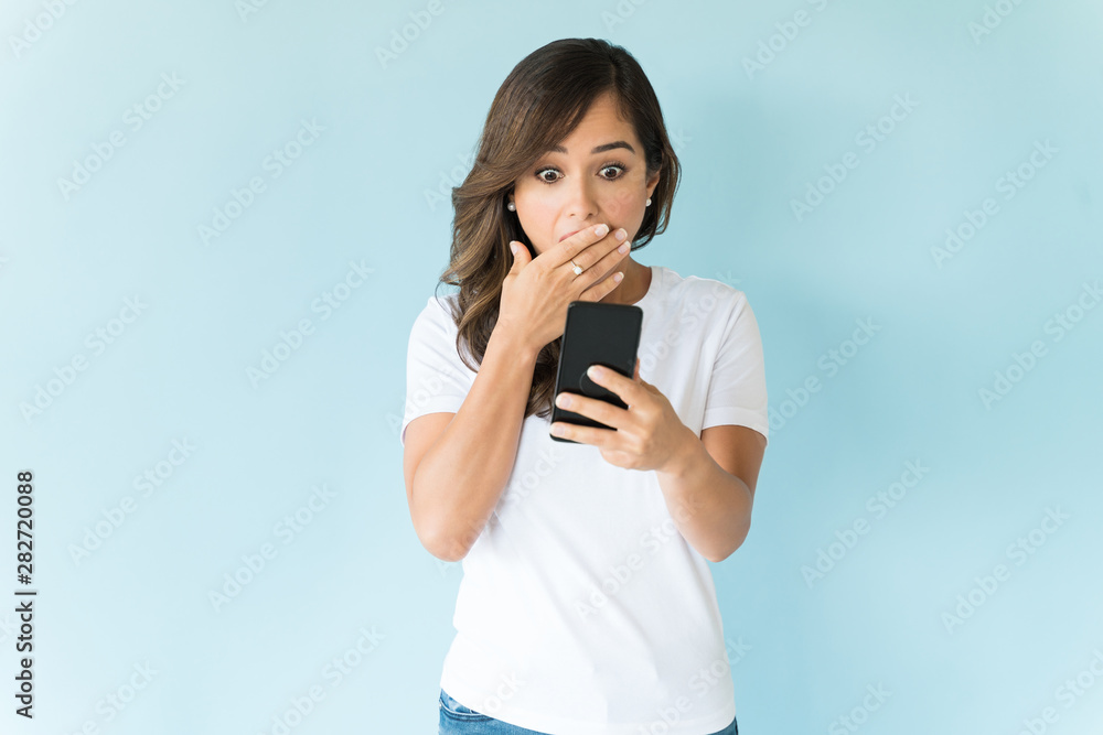 Shocked Beautiful Female Using Mobile Phone In Studio Shocked Beautiful Female Using Mobile Phone In Studio