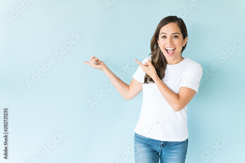 Cheerful Woman Pointing Against Isolated Background photo