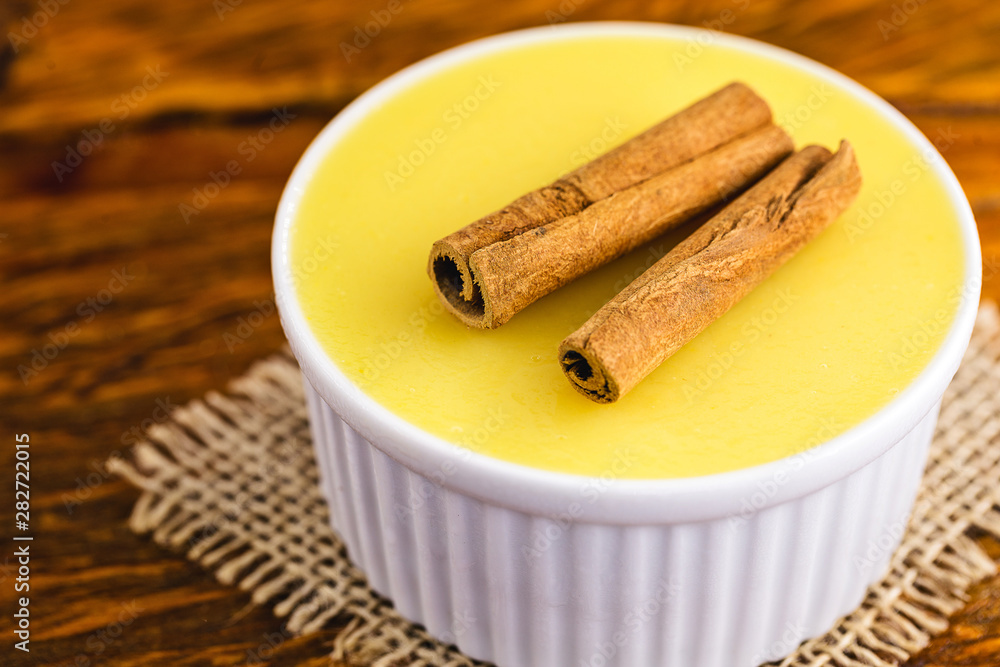 Typical Brazilian dessert, sweet of mingua, called in Brazil of curau. Typical sweet of June party. Brazilian sweet corn, corn mousse on a wooden background with copy space. Typical Brazilian dessert, sweet of mingua, called in Brazil of curau. Typical sweet of June party. Brazilian sweet corn, corn mousse on a wooden background with copy space.