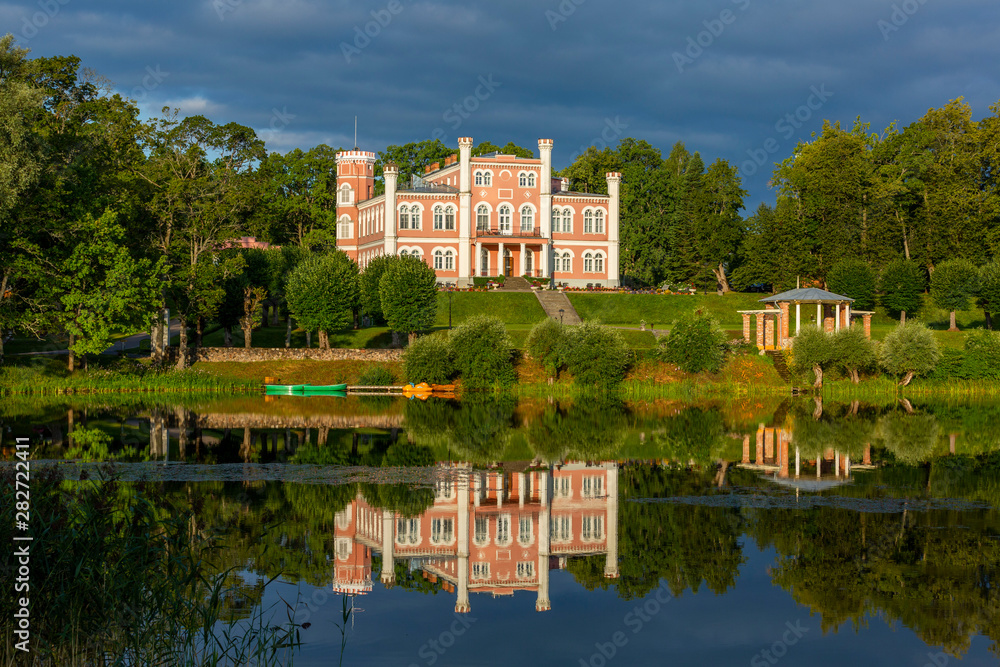 Birini palace and mirror reflection in Birinyu lake, Latvia