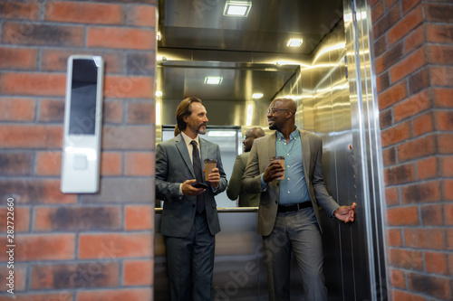 Businessman having small talk in the elevator in the morning