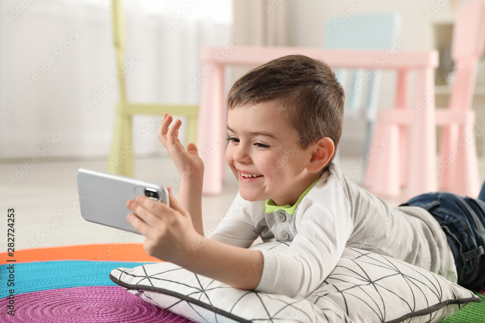 Little boy using video chat on smartphone in playroom Little boy using video chat on smartphone in playroom