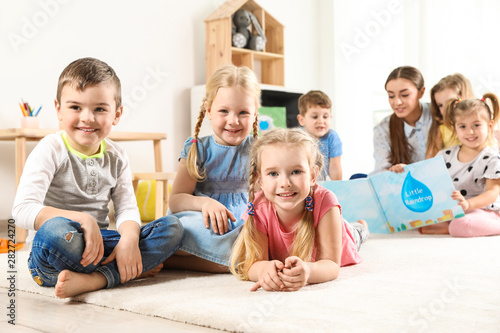 Playful little children resting on floor indoors