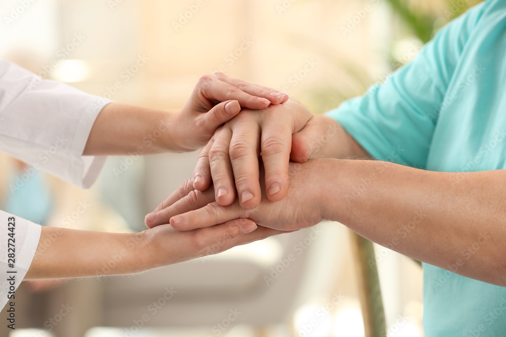 Nurse comforting elderly man indoors, closeup. Assisting senior generation Nurse comforting elderly man indoors, closeup. Assisting senior generation