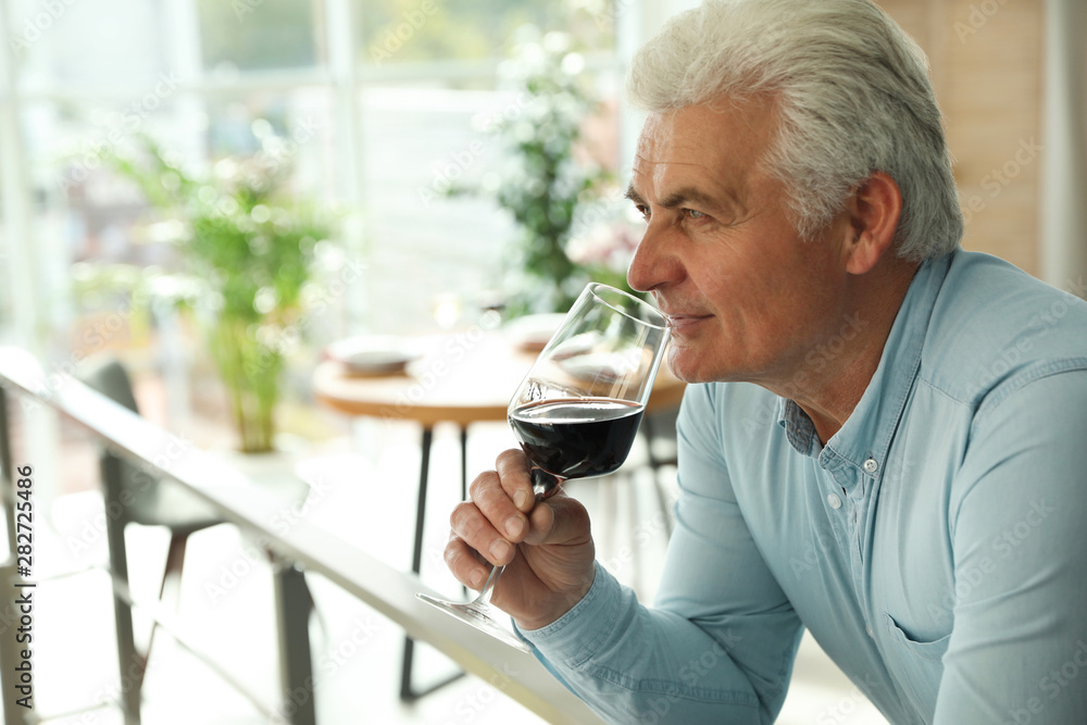 Senior man with glass of wine in restaurant. Space for text Senior man with glass of wine in restaurant. Space for text