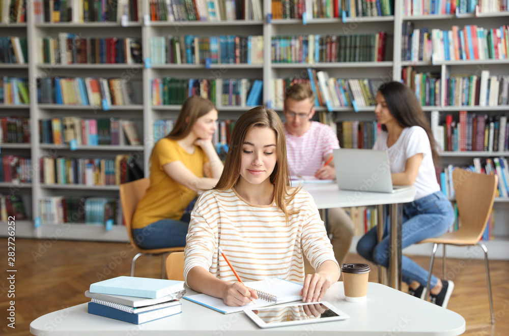 Young woman studying at table in library Young woman studying at table in library