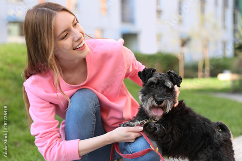 Young woman with Miniature Schnauzer dog outdoors photo