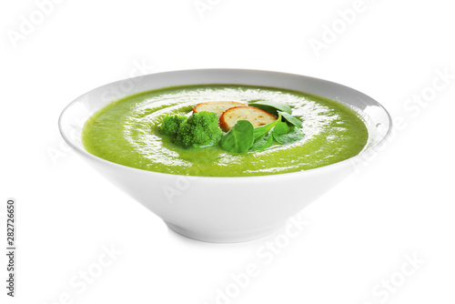 Bowl of broccoli cream soup with croutons on white background