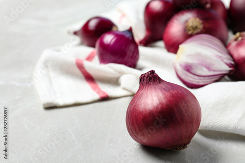 Fresh whole red onion bulbs on marble table. Space for text