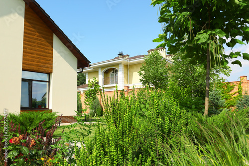 Beautiful green garden near modern house on sunny day © New Africa