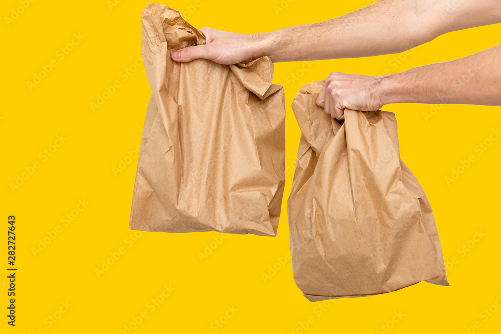 Diverse of paper containers for takeaway food. Delivery man is carrying yellow, orange, background Diverse of paper containers for takeaway food. Delivery man is carrying yellow, orange, background