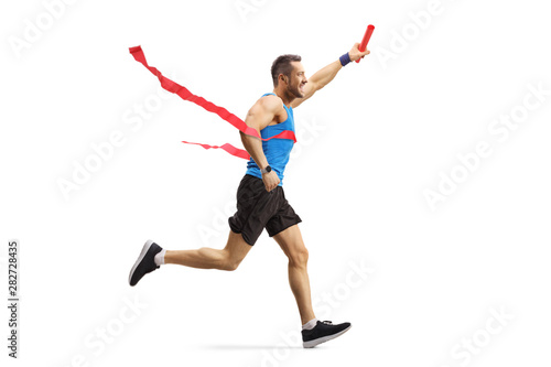 Young man finishing a relay race and holding a baton