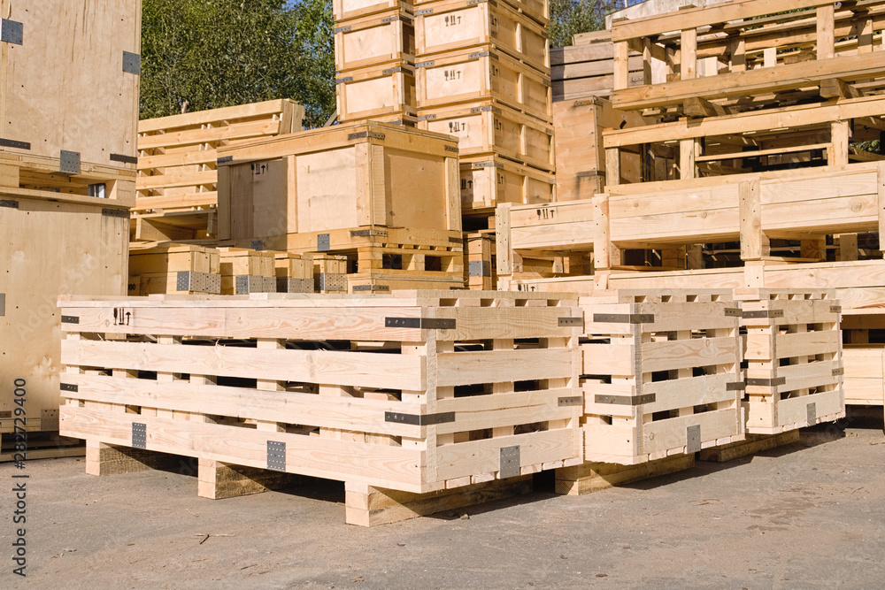 A industrial wooden boxs stands on the pavement in an open summer warehouse on a concrete wall background. Industrial containers made of wood.