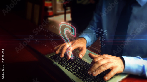 Man typing on keyboard with question mark symbol hologram photo