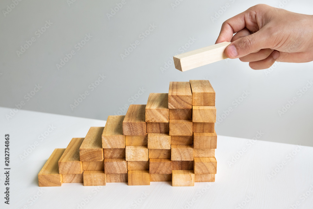 Hand holding blocks wood game, Concept Risk of management and strategy plan, growth business success process and team work Hand holding blocks wood game, Concept Risk of management and strategy plan, growth business success process and team work
