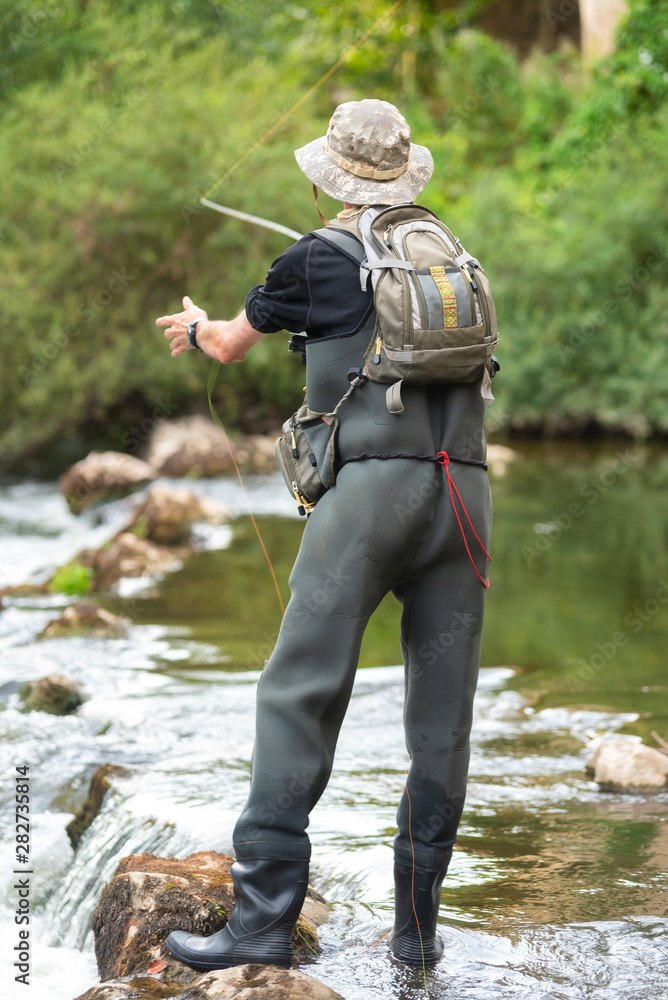 Fisherman fishing on the River, holding Fishing Rod . Fisherman fishing on the River, holding Fishing Rod .