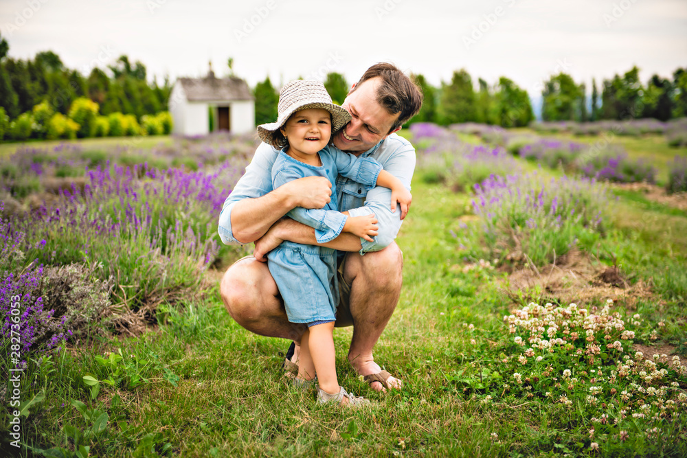 Happy family father and daughter having fun in lavender field
