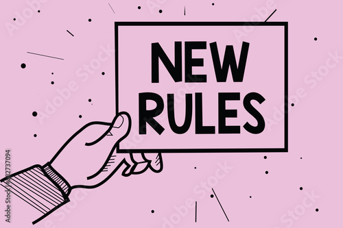 Word writing text New Rules. Business concept for A state of changing an iplemented policy for better upgrade Man hand holding paper communicating information dotted purple background photo