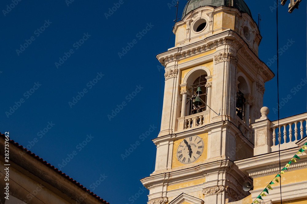The bell tower of the main church of the town, with the clock in the foreground.